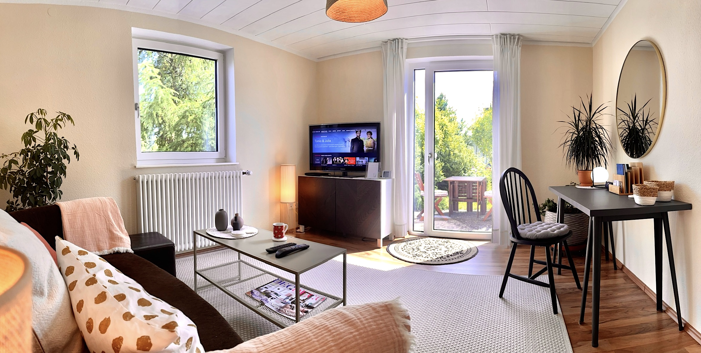 Wohnzimmer mit Homeoffice Space und Blick auf die Süd-Terrasse und ins Grüne